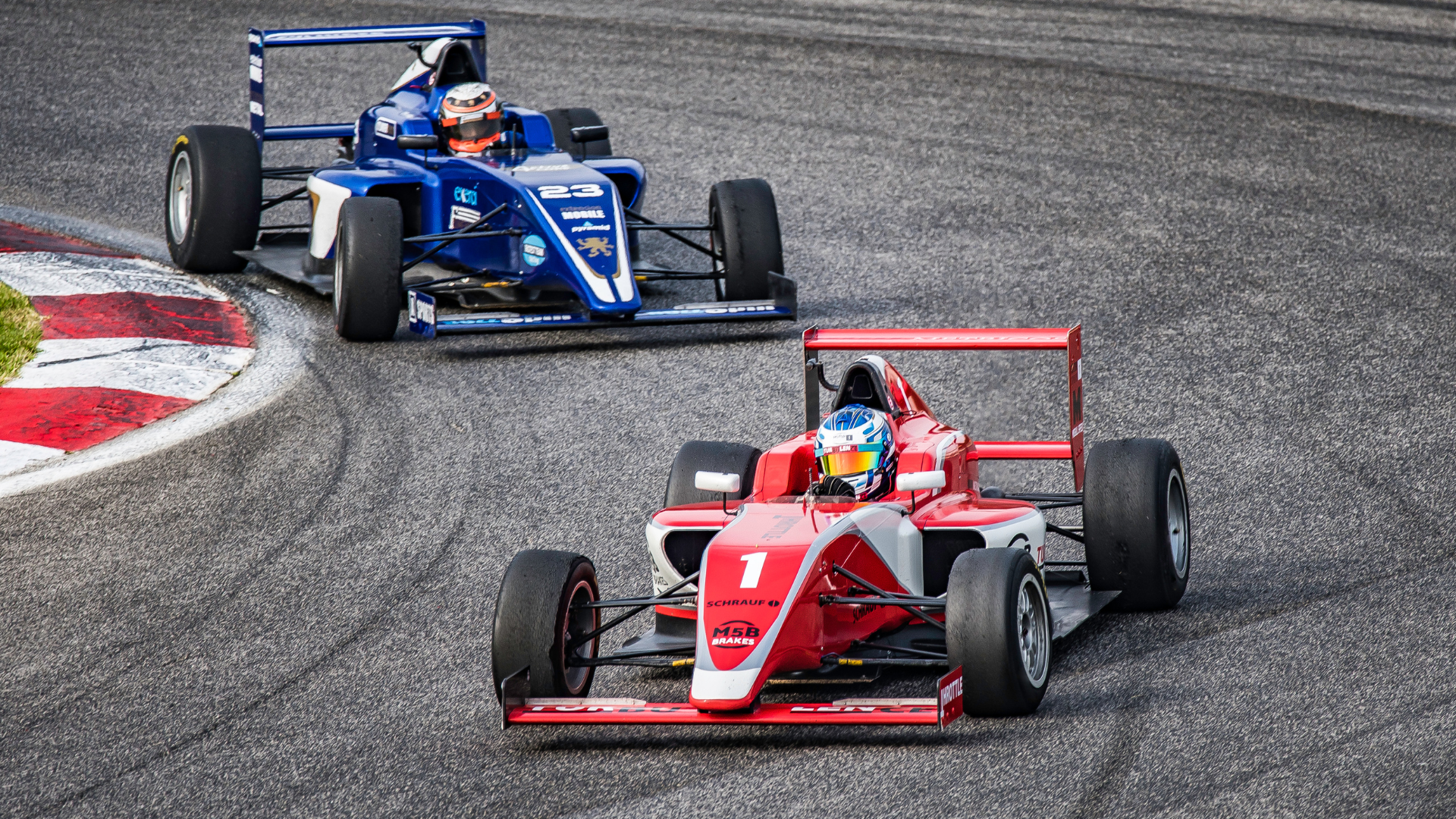 Two open-wheel race cars on a racing track, one red and white with the number 1, and one blue with the number 23, navigating a curve. Racing for kids. Racing TV show for kids. Racing show for kids. 