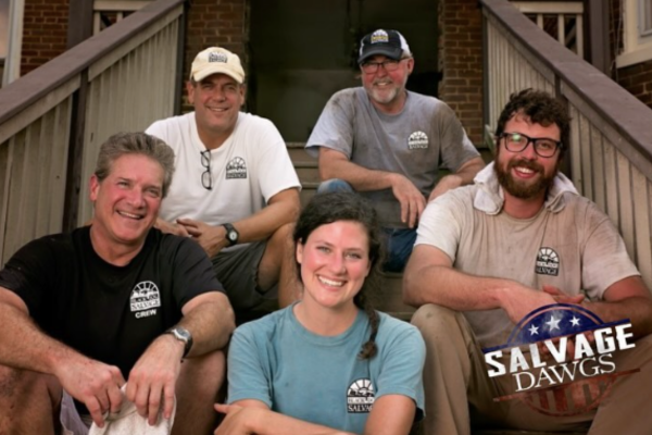 Group of five smiling people sitting on steps outside, wearing Salvage Dawgs shirts. Tay Whiteside from Salvage Dawgs.
