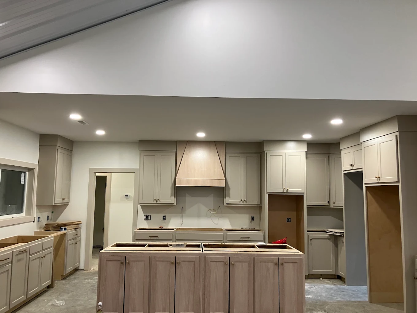 Kitchen under renovation with unfinished cabinets and appliances