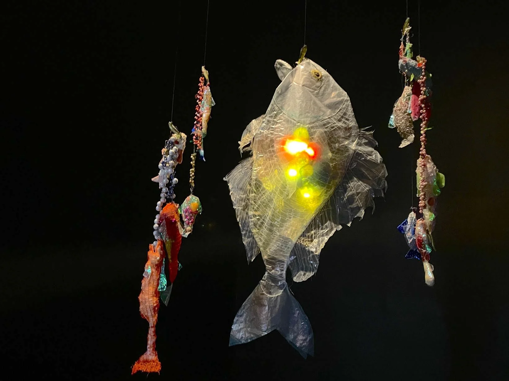Fish Friends, plastic fish lamp made of beads, fishing lures, found objects, 2'x3.5', 2023