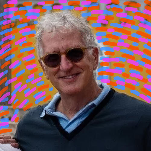 A smiling man with curly gray hair and sunglasses, standing outdoors with a colorful, abstract background of bright orange, pink, purple, and blue strokes.
