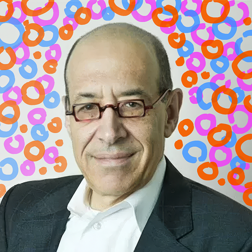 A man in glasses and a suit, smiling, with colorful abstract circles in the background.