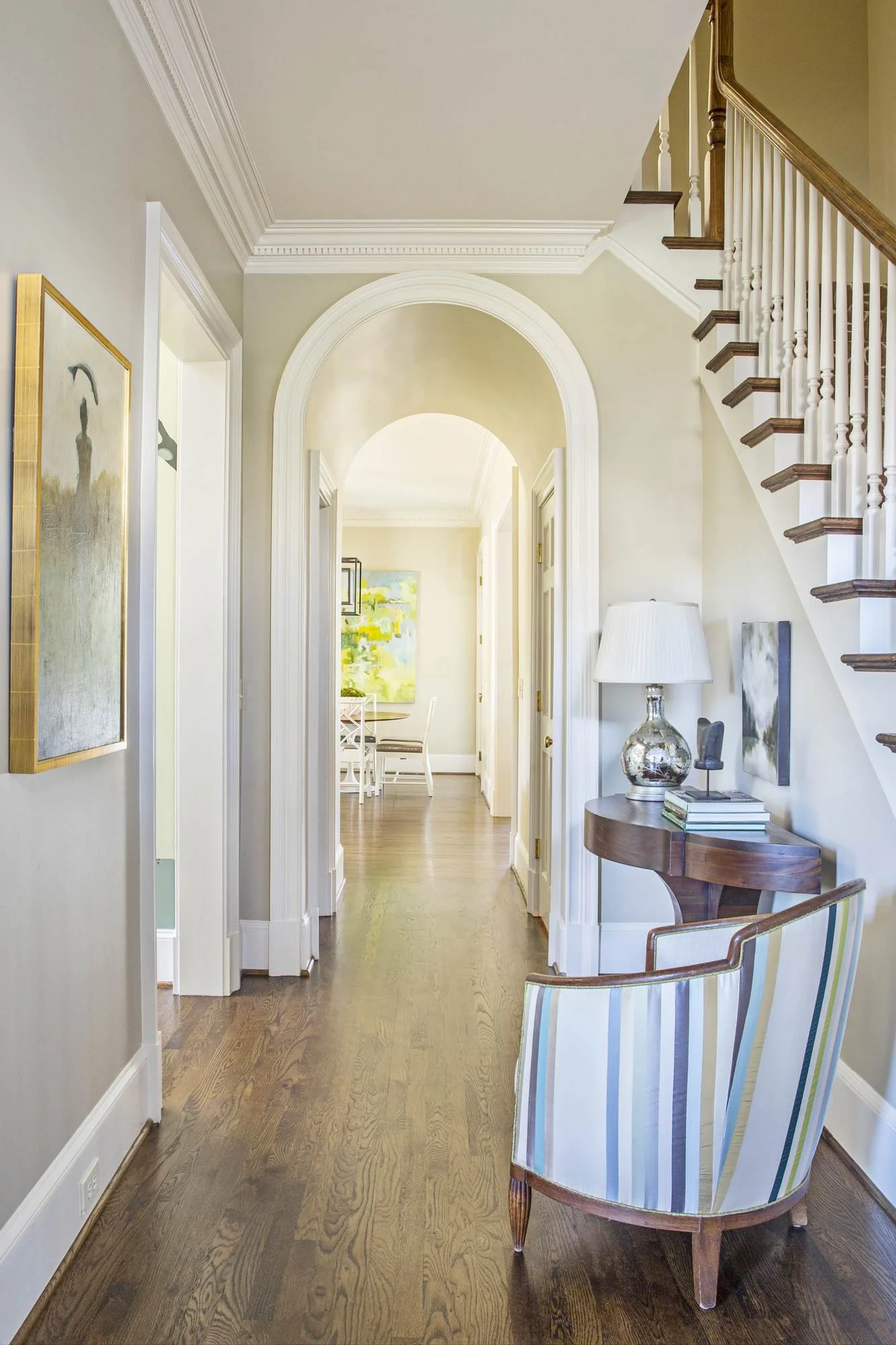 cofield-atlanta-residential-interior-design-hallway-arched-doorway-staircase-striped-chair.jpg