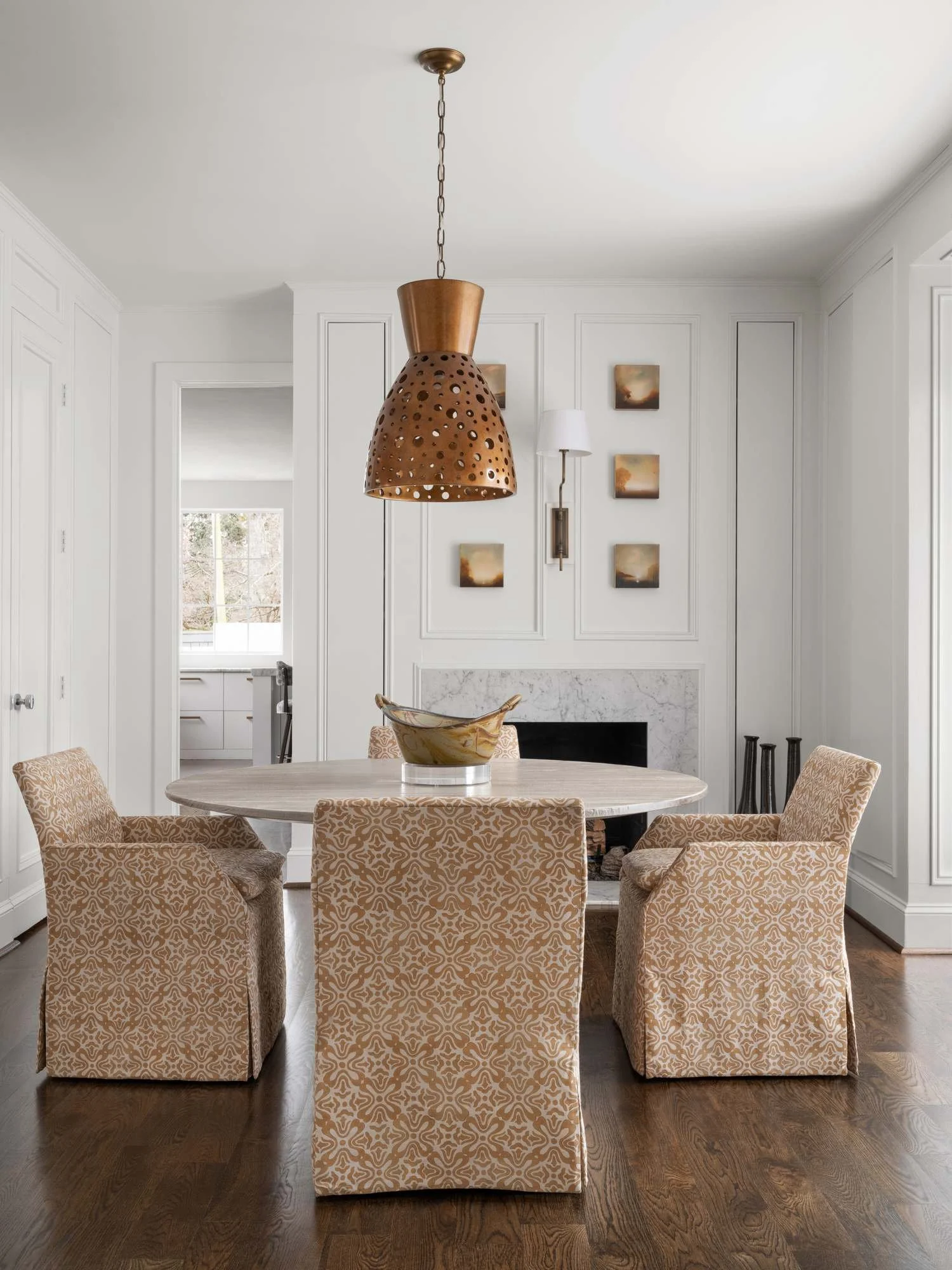 Peachtree-Battle-dining-room-skirted-chairs-perforated-brass-pendant-marble-fireplace.jpg
