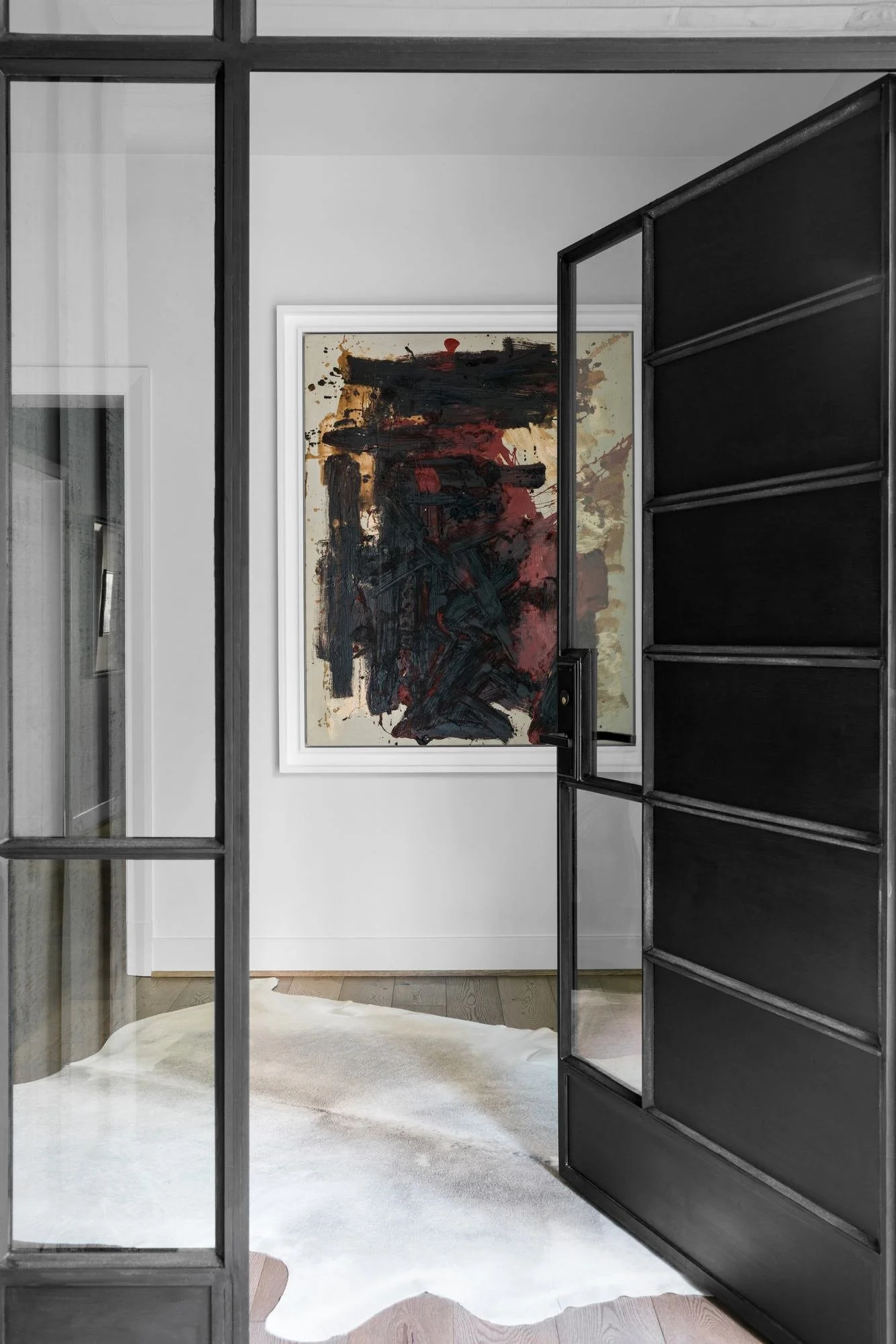 millwalk-atlanta-residential-interior-design-entry-steel-door-abstract-art-cowhide-rug.jpg
