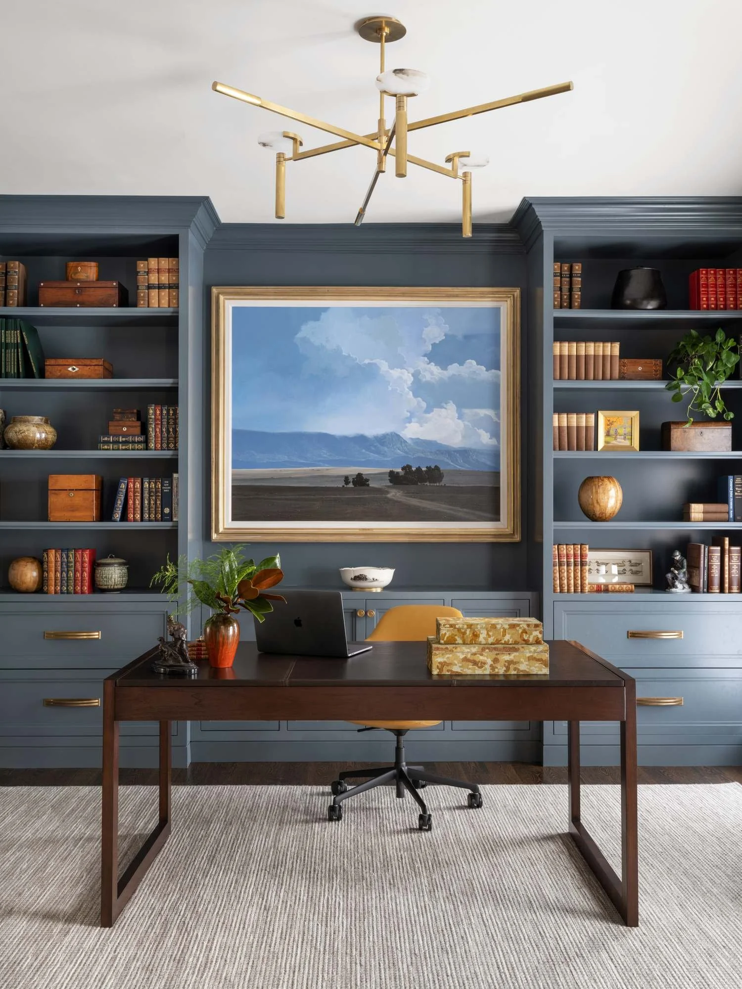 Peachtree-Battle-home-office-blue-built-ins-landscape-painting-brass-chandelier.jpg