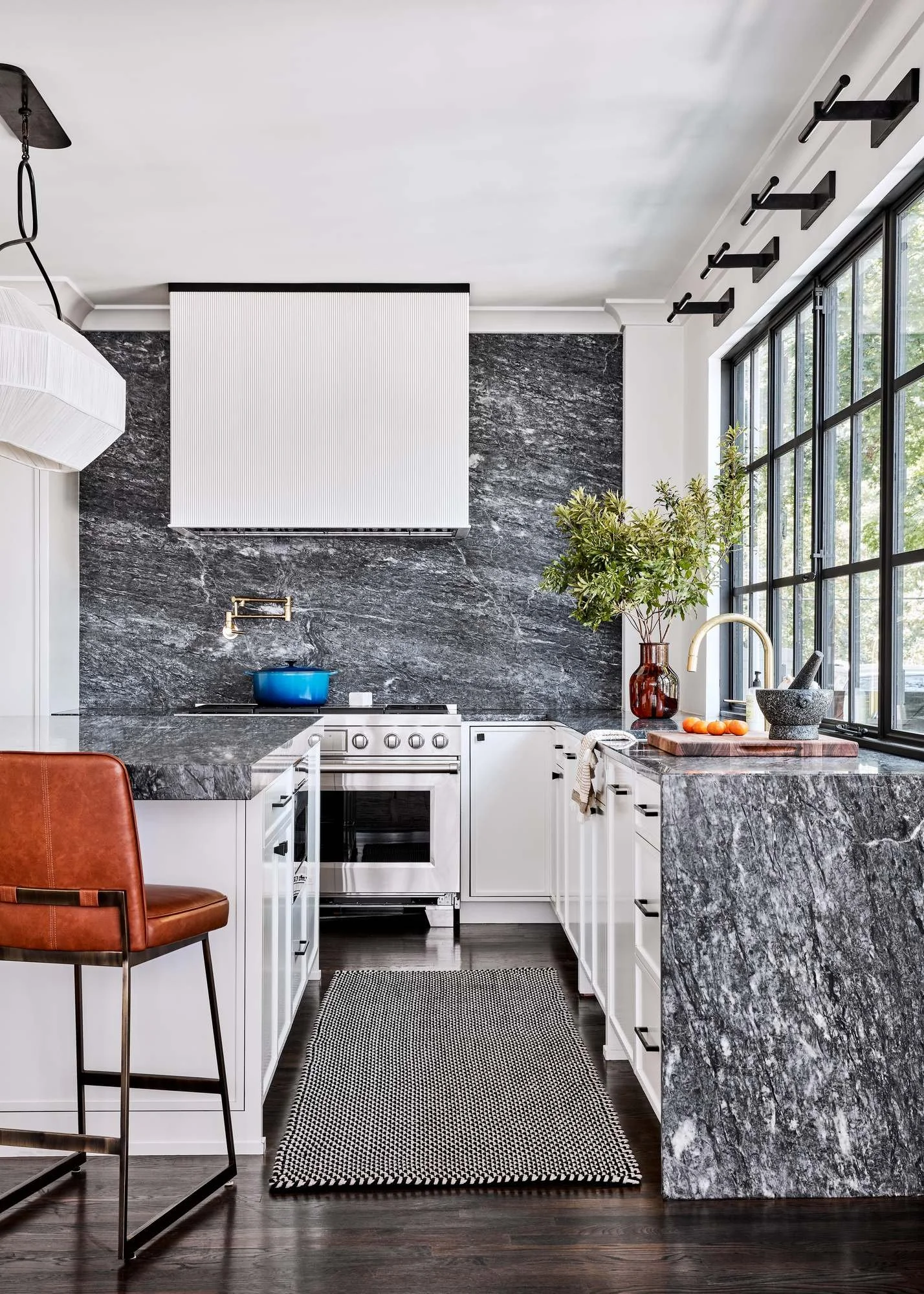 Woodward-Way-kitchen-dark-stone-counters-white-cabinets-steel-windows.jpg