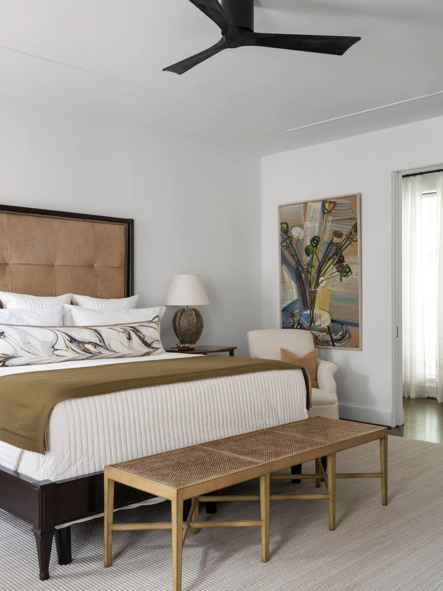 Peachtree-Battle-primary-bedroom-leather-headboard-cane-bench-abstract-art.jpg