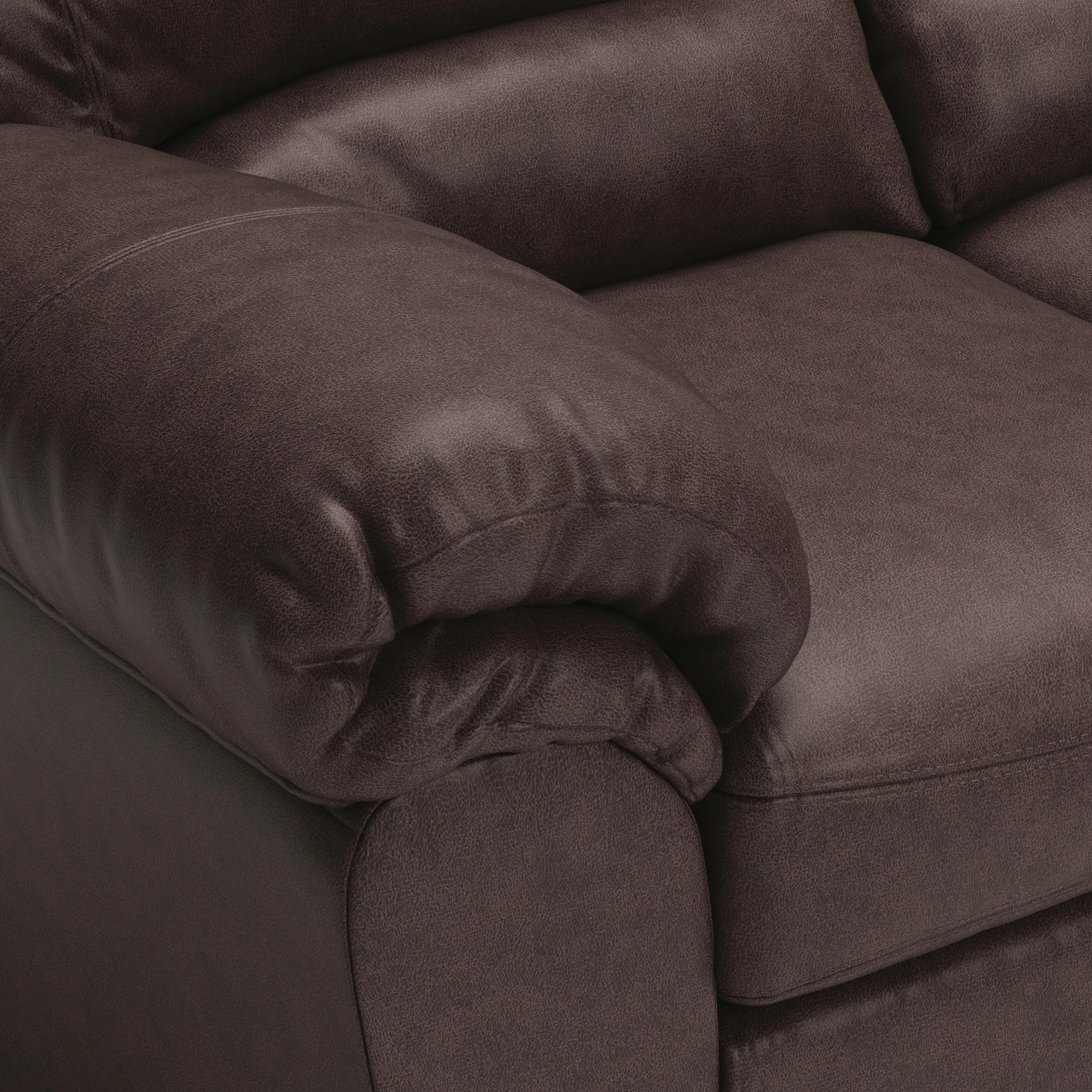 Close-up of the Weston sectional showcasing the faux leather upholstery, jumbo stitching, plush cushions, and quality craftsmanship.