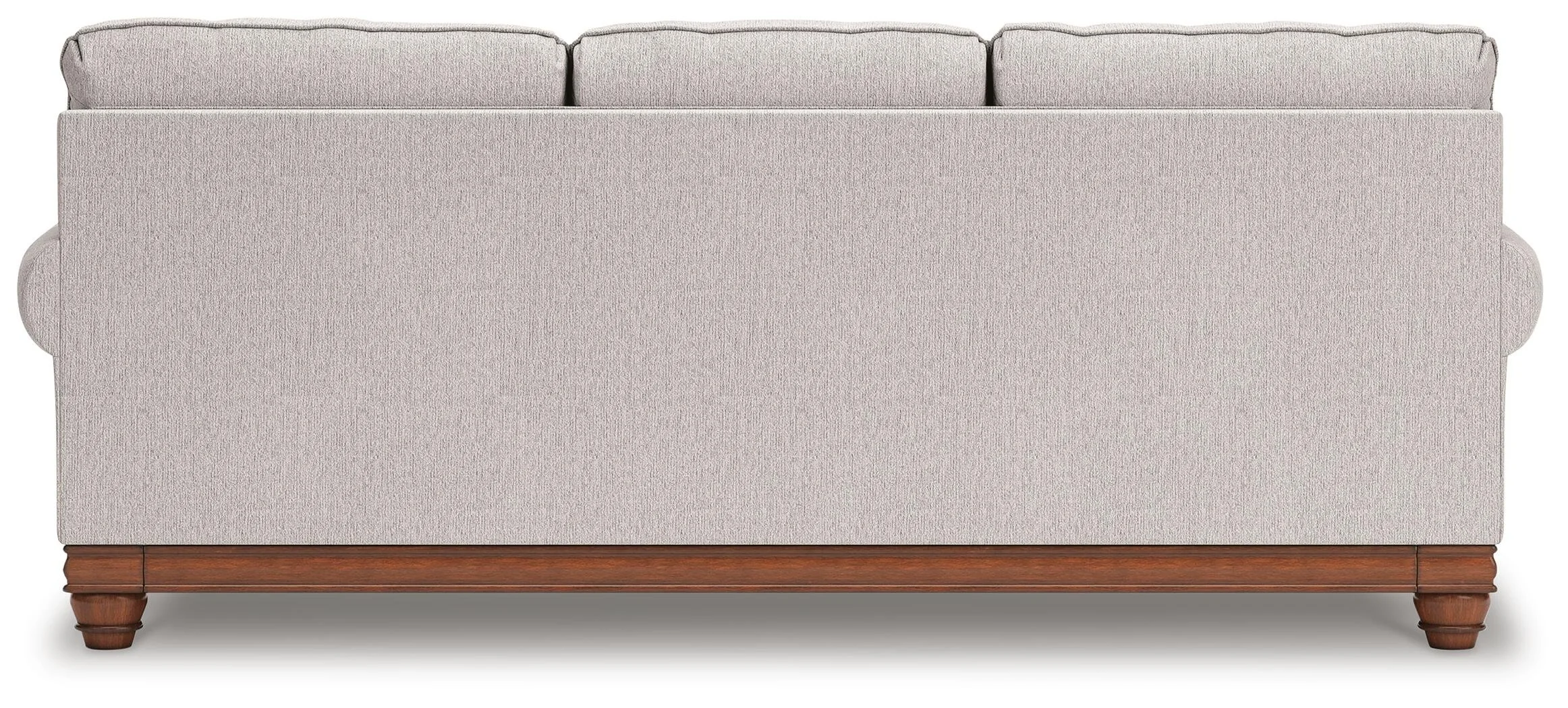 Farmhouse-inspired sofa with soft neutral upholstery, reversible cushions, decorative turned legs, and coordinating plaid accent pillows.