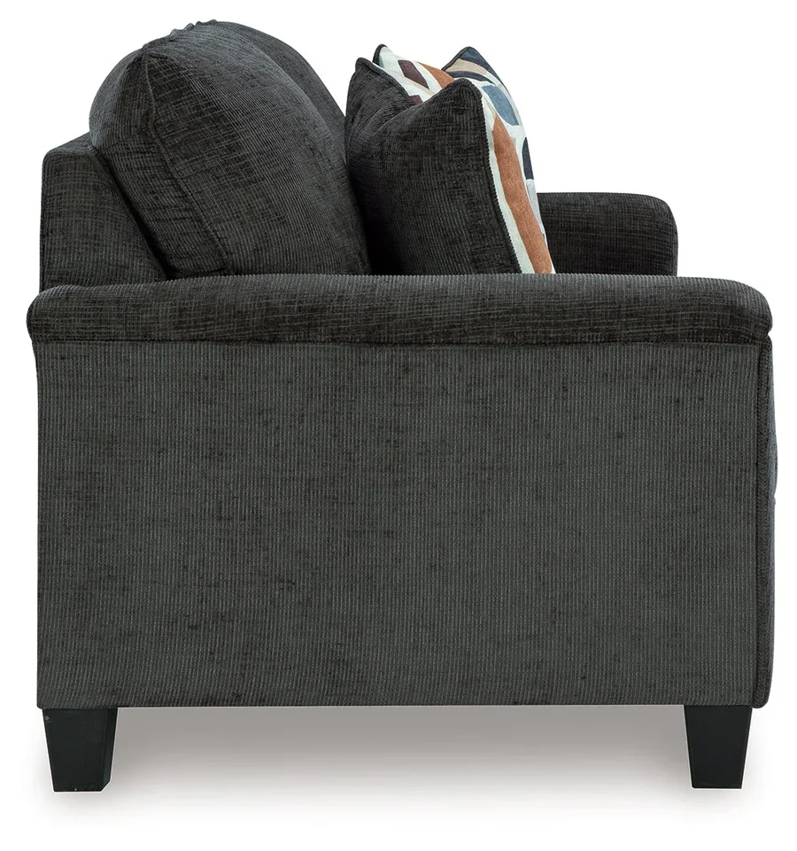 Contemporary sofa with soft polyester upholstery, tapered faux wood legs, and coordinating accent pillows.