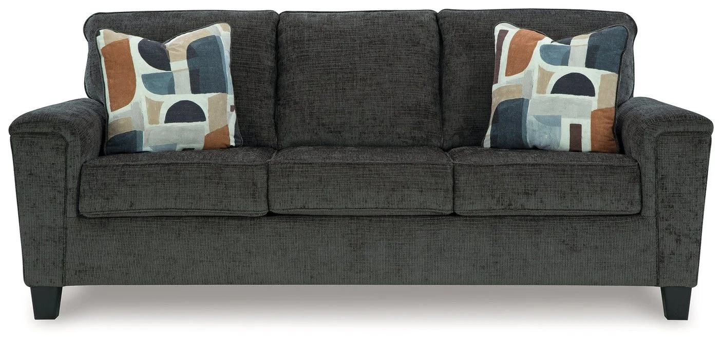 Contemporary sofa with soft polyester upholstery, tapered faux wood legs, and coordinating accent pillows.