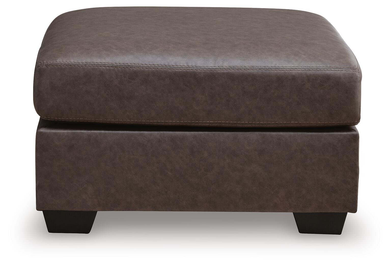Matching oversized faux leather ottoman with plush cushioning and contemporary styling.