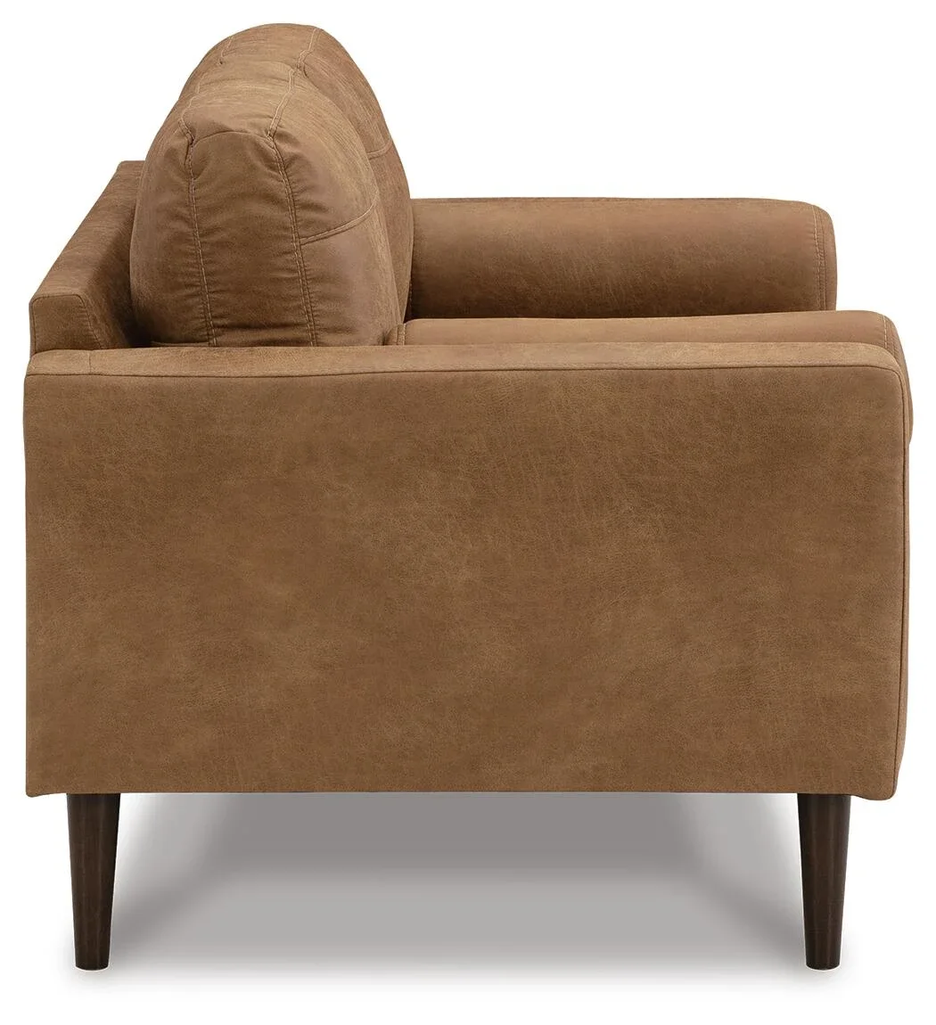 Matching loveseat with caramel faux leather upholstery, loose cushions, bolster pillows, and contemporary styling.