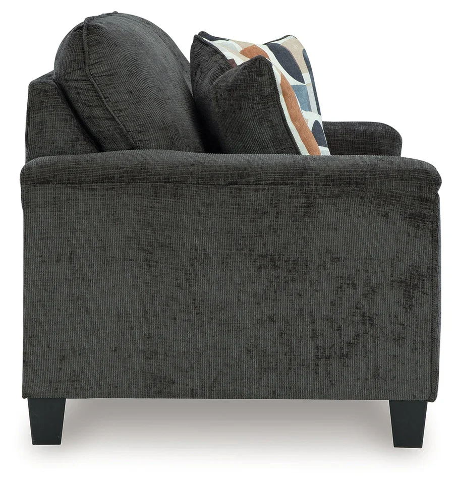 Matching contemporary loveseat with plush polyester upholstery, tapered faux wood legs, and coordinating accent pillows.