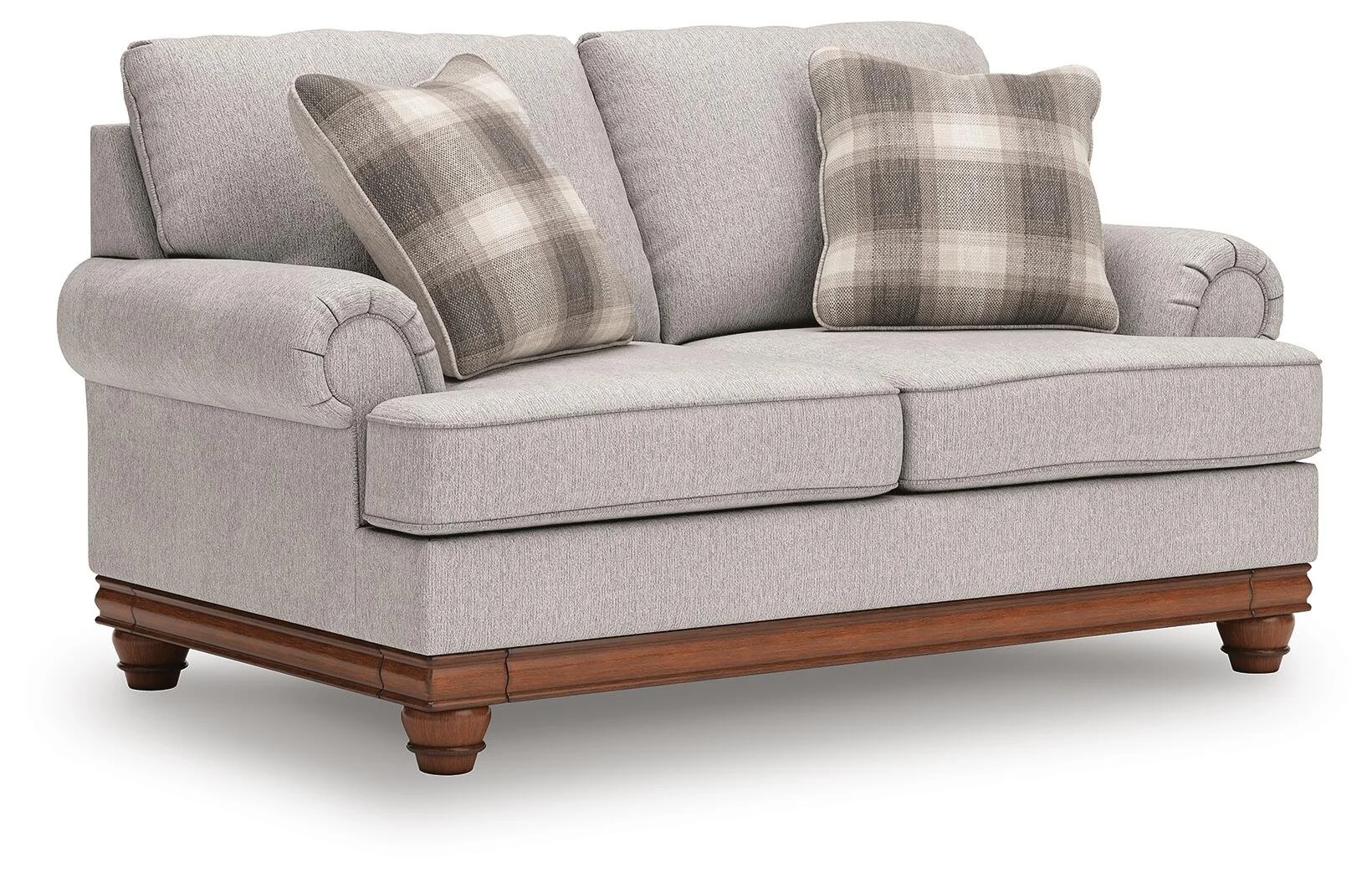 Matching farmhouse loveseat with soft neutral upholstery, reversible cushions, decorative turned legs, and coordinating accent pillows.