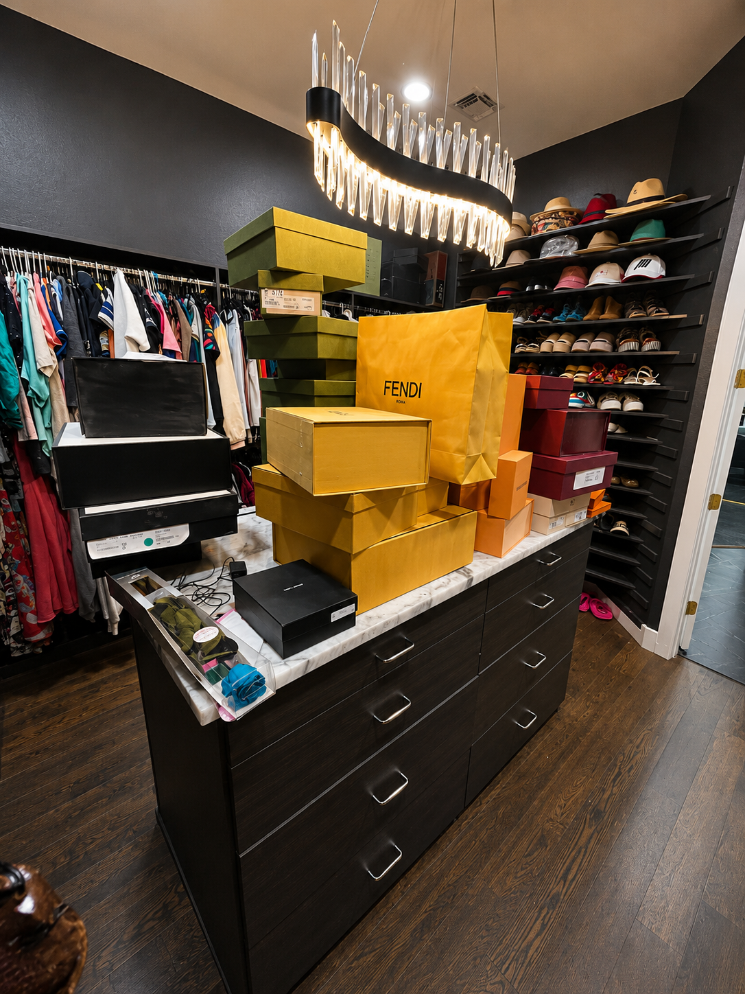 A retail store counter with stacked branded shopping bags and boxes, including Fendi and Louis Vuitton, surrounded by clothing racks and shoe shelves.