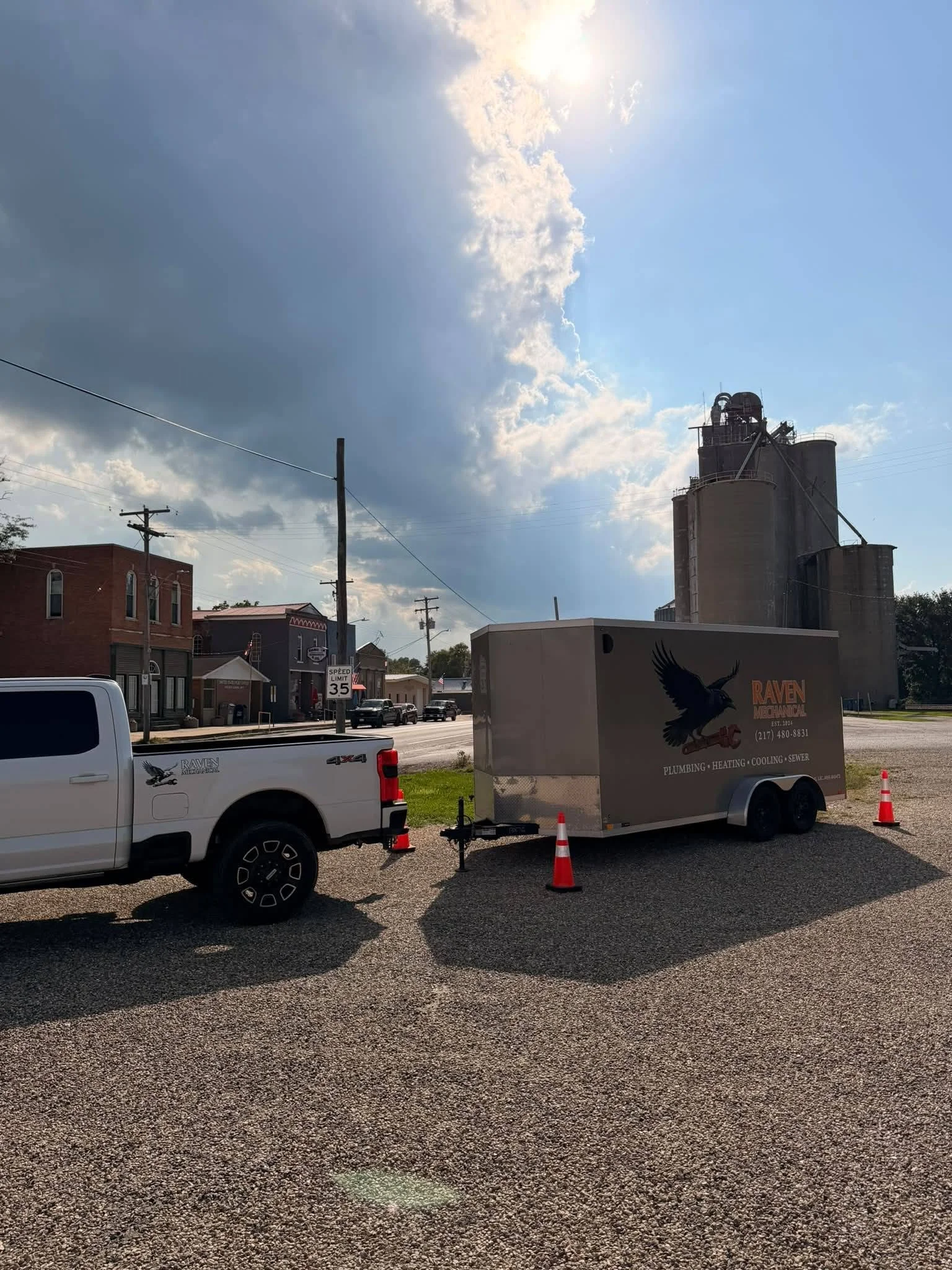 Picture of white truck with Raven Mechanical trailer behind and orange cones around