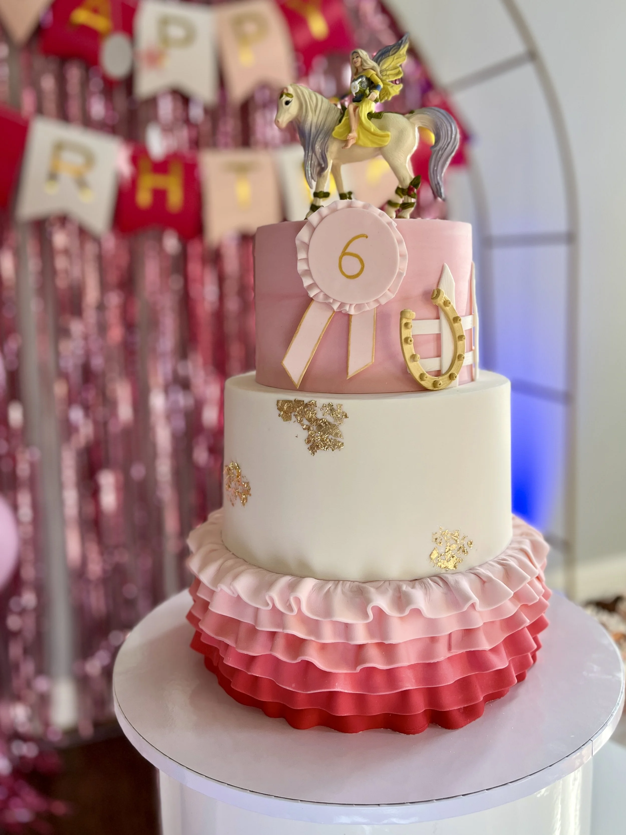 White tiered cake with a pink checked lower tier and butterfly decorations.