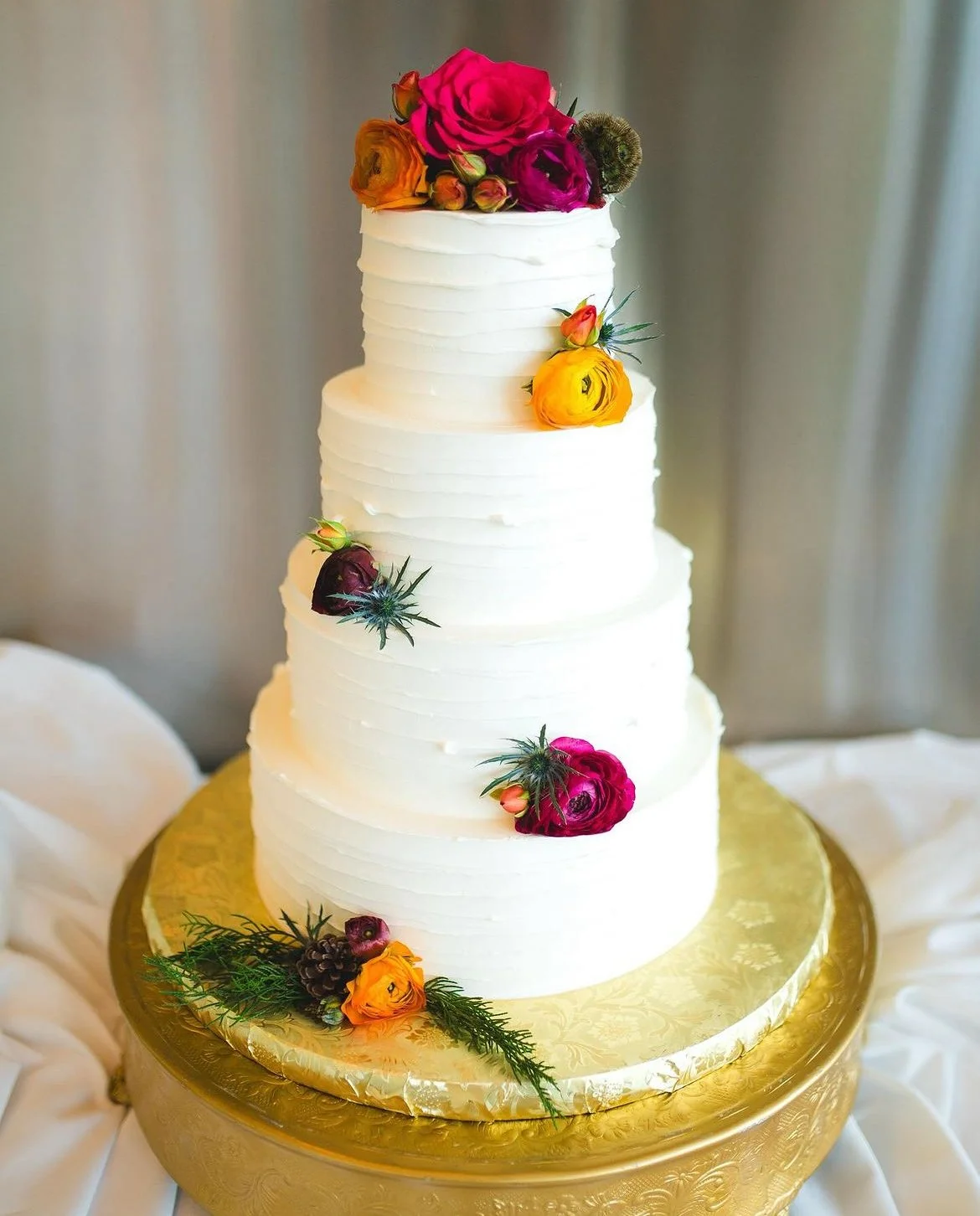 White tiered cake accented with colorful flowers.