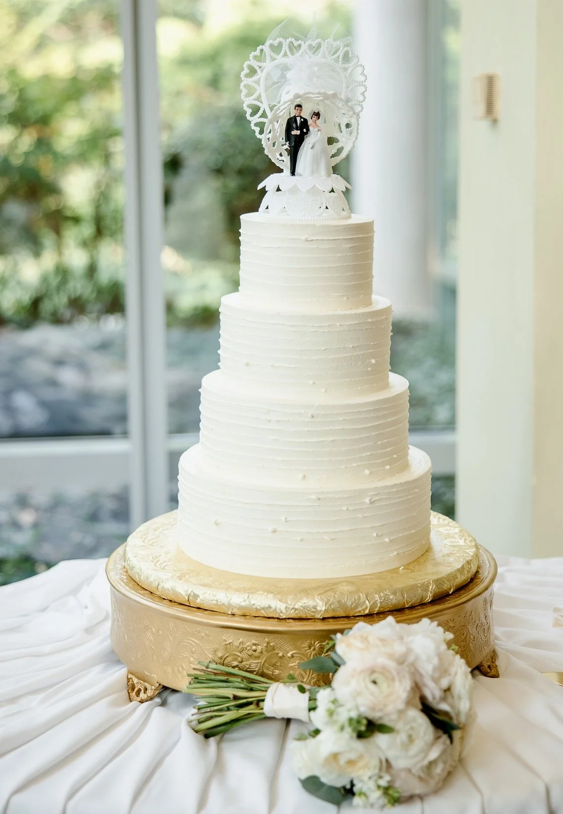 White tiered cake with fine horizontal icing texture.