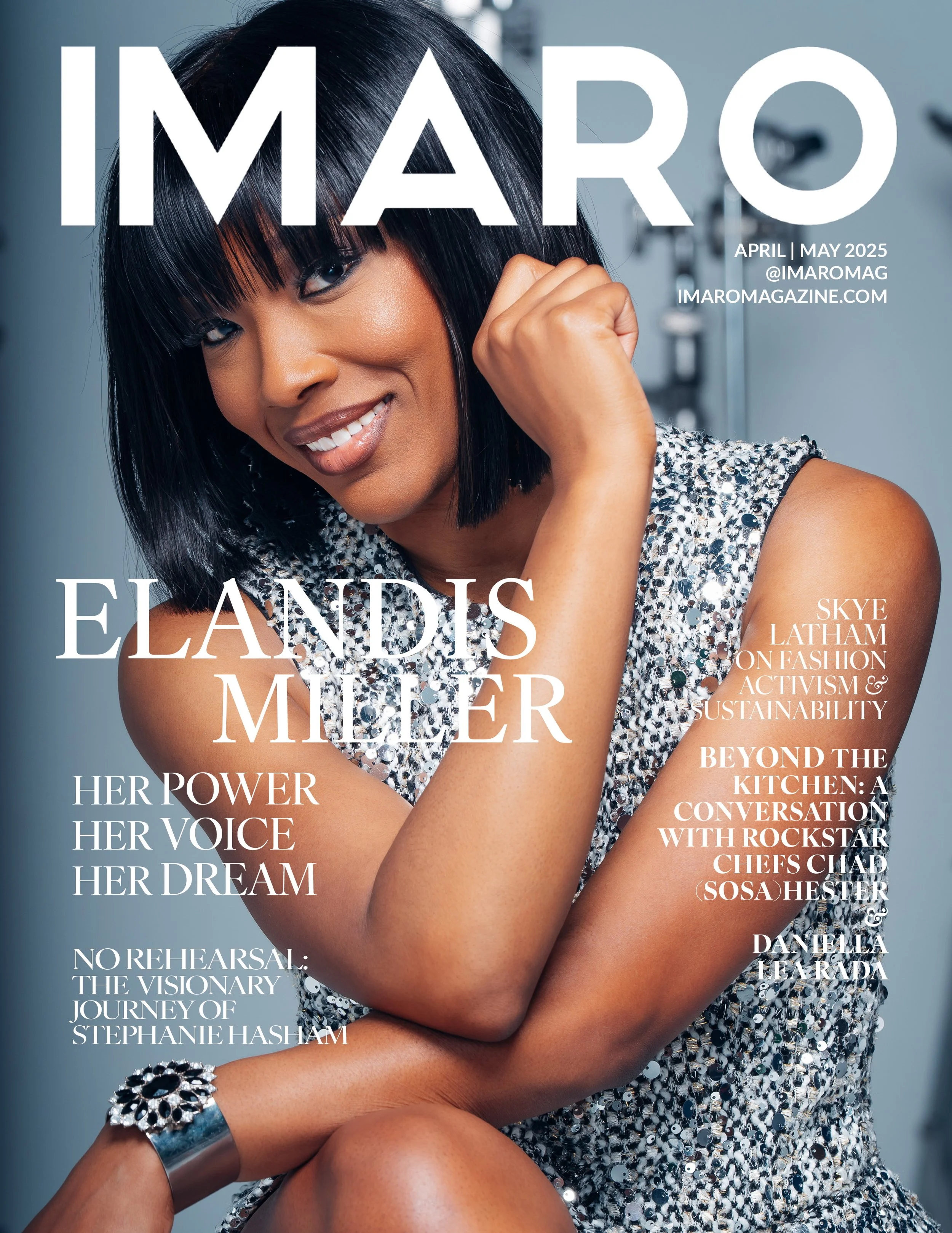 Close-up of a woman with black hair in a bob with blunt bangs, smiling, wearing a sparkly silver dress and bracelet, against a gray background, with magazine cover text overlay.