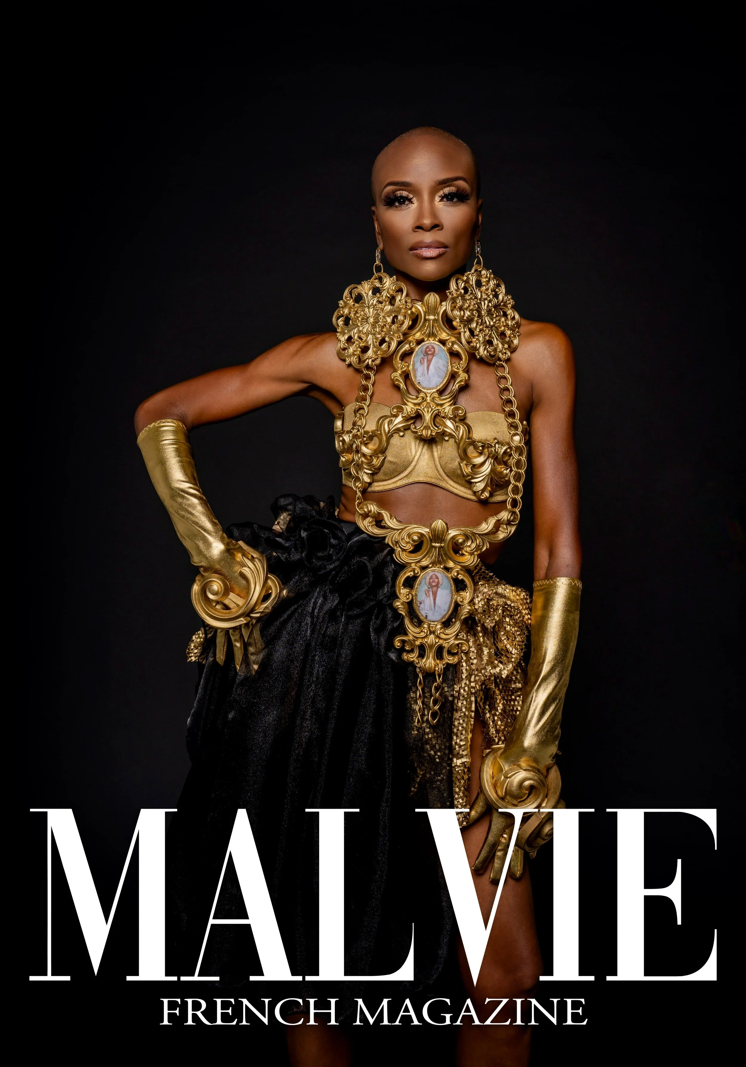 Cover of Malvie French Magazine featuring a woman with a shaved head dressed in gold and black ornate jewelry and clothing, standing against a black background.