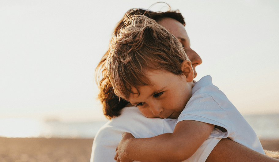 Mother and child hugging at the beach