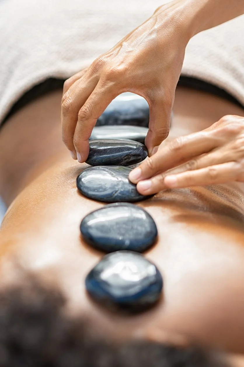 Hot stone massage with stones lined up along client's spine.