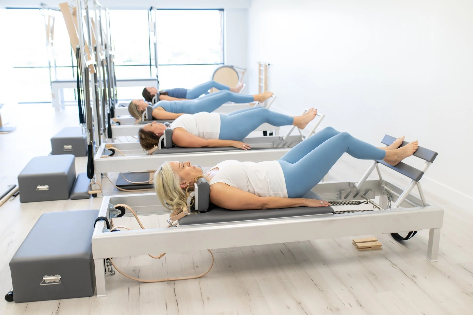 Small Group Reformer Pilates clients practicing Footwork at TruForm Pilates in Scottsdale