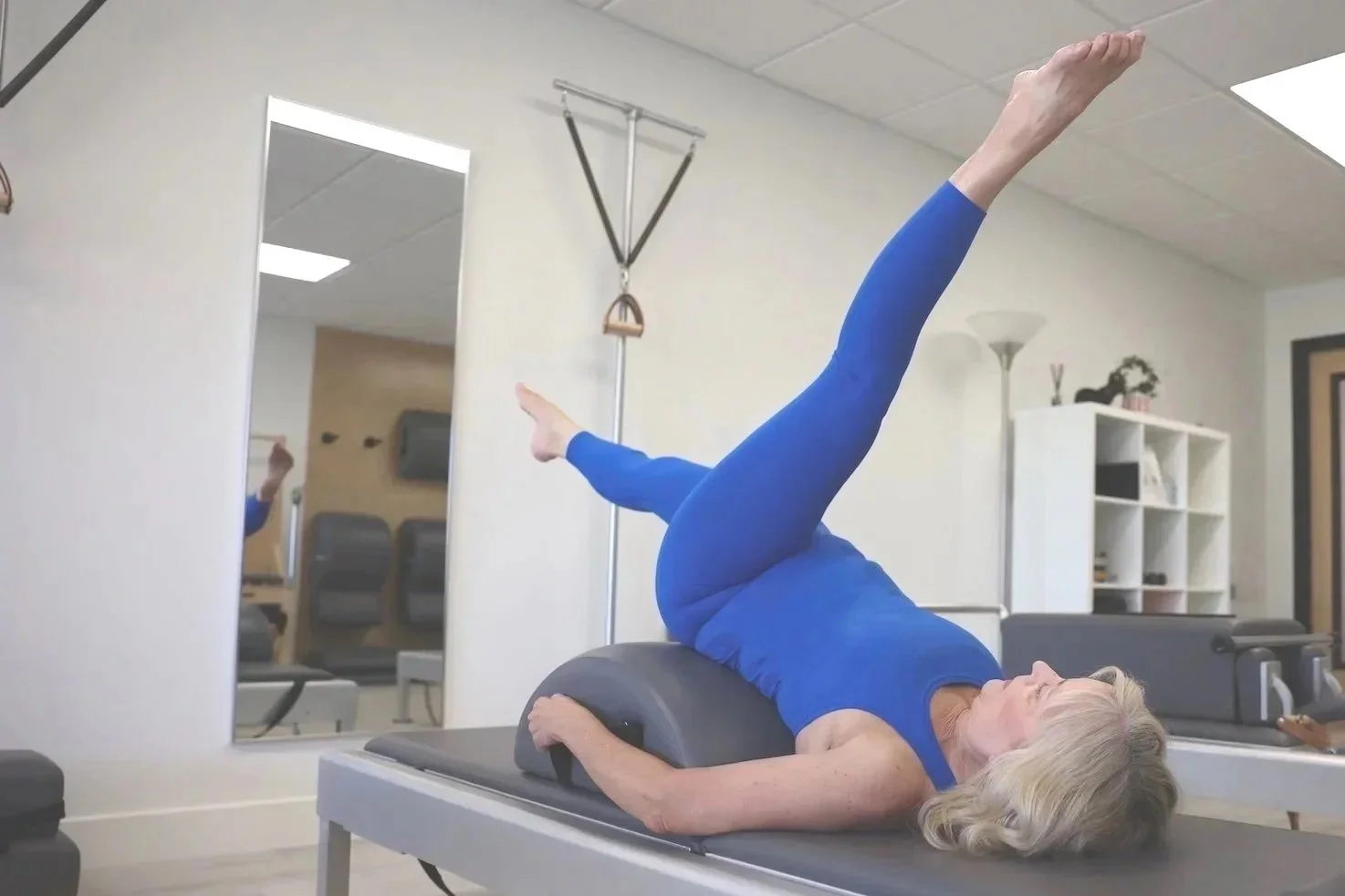 Client practicing Scissors on Pilates Barrel at TruForm Pilates