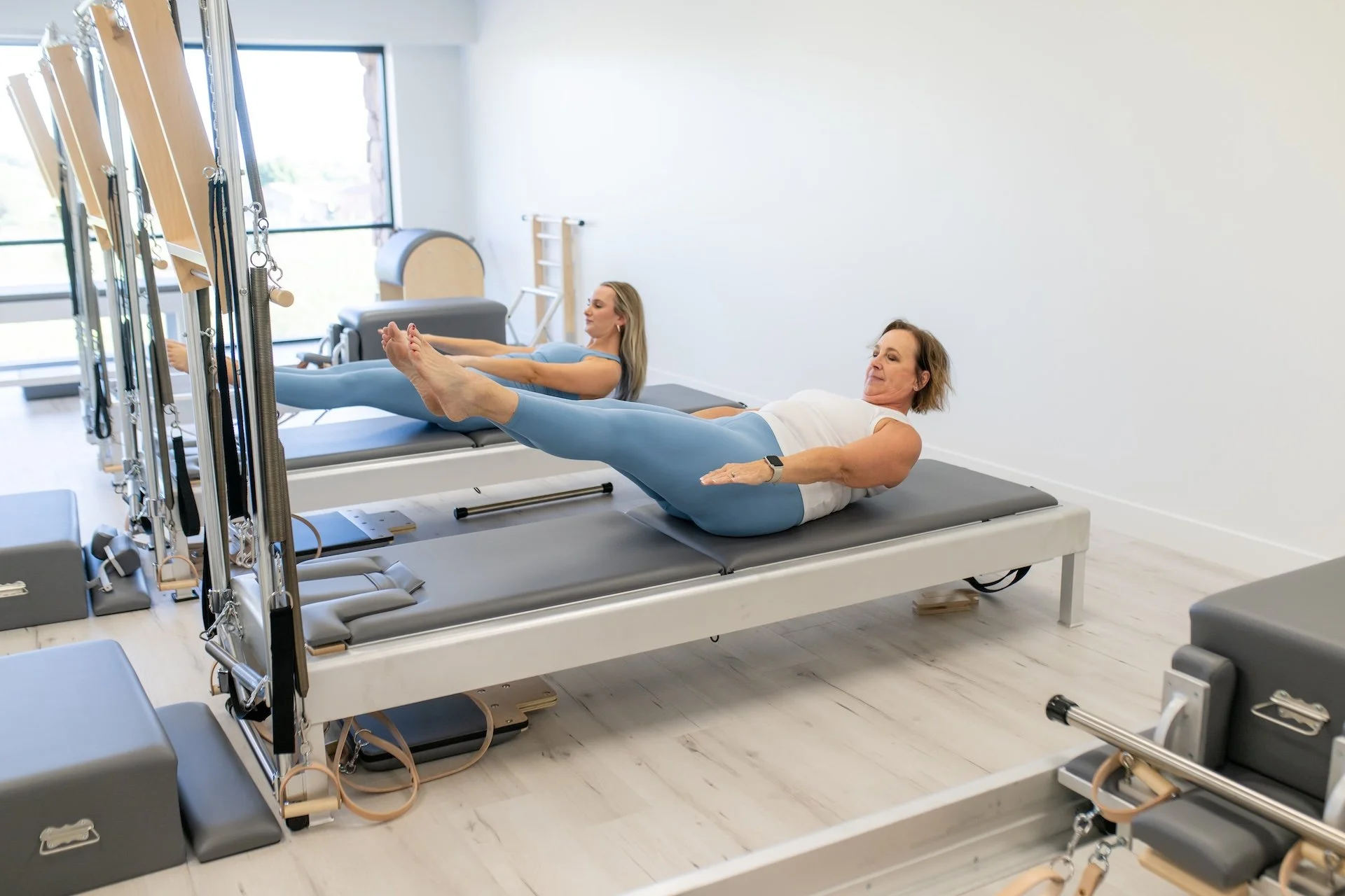 Clients practicing the Hundred during personalized Pilates instruction at TruForm Pilates Scottsdale