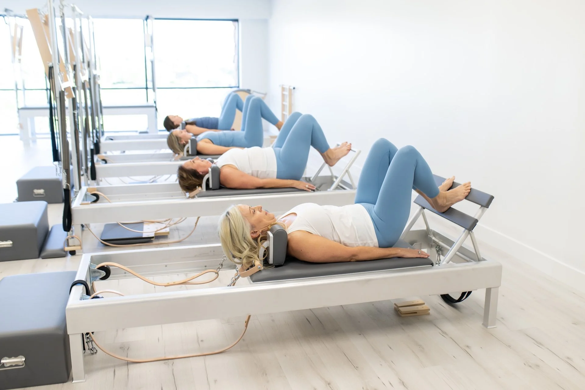 Instructor-led Classical Pilates class with multiple clients on apparatus
