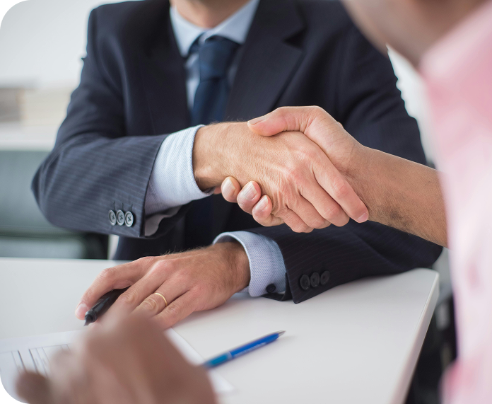 Dos personas dándose la mano en un acuerdo de negocios.