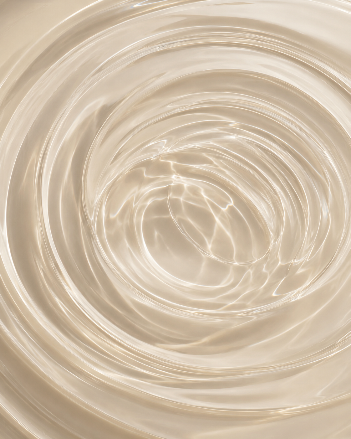 Close-up of rippling water with light reflections creating circular patterns.