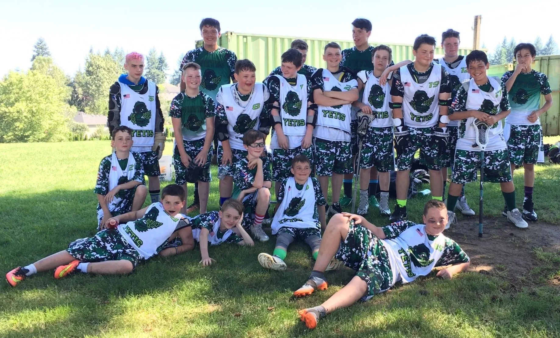 Yetis youth lacrosse team posing together on a grass field.