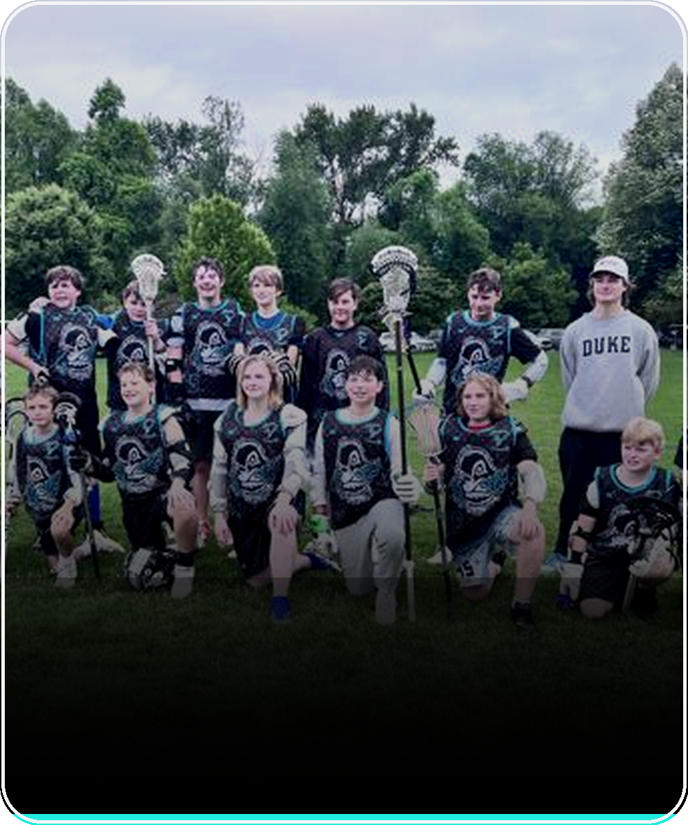 Yetis youth lacrosse team and coach posing together on a grass field.
