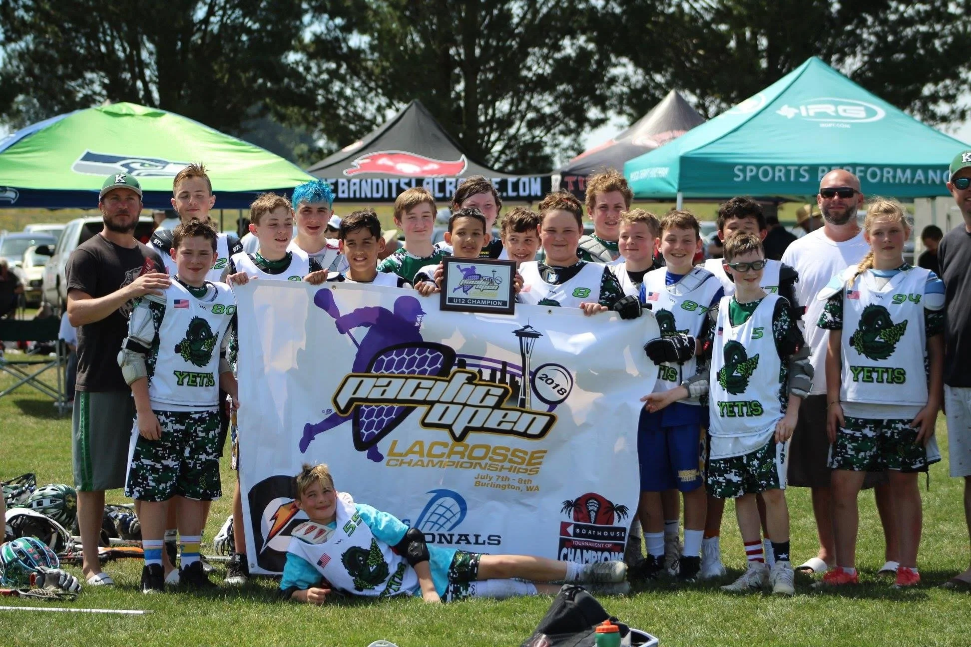 Yetis youth lacrosse players and coaches celebrating at an outdoor championship event.