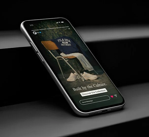 Smartphone displaying a website with a vintage school chair, a backpack, and sneakers, featuring the text 'Built by the Culture' and buttons for 'Discover the Collection' and sending a message.