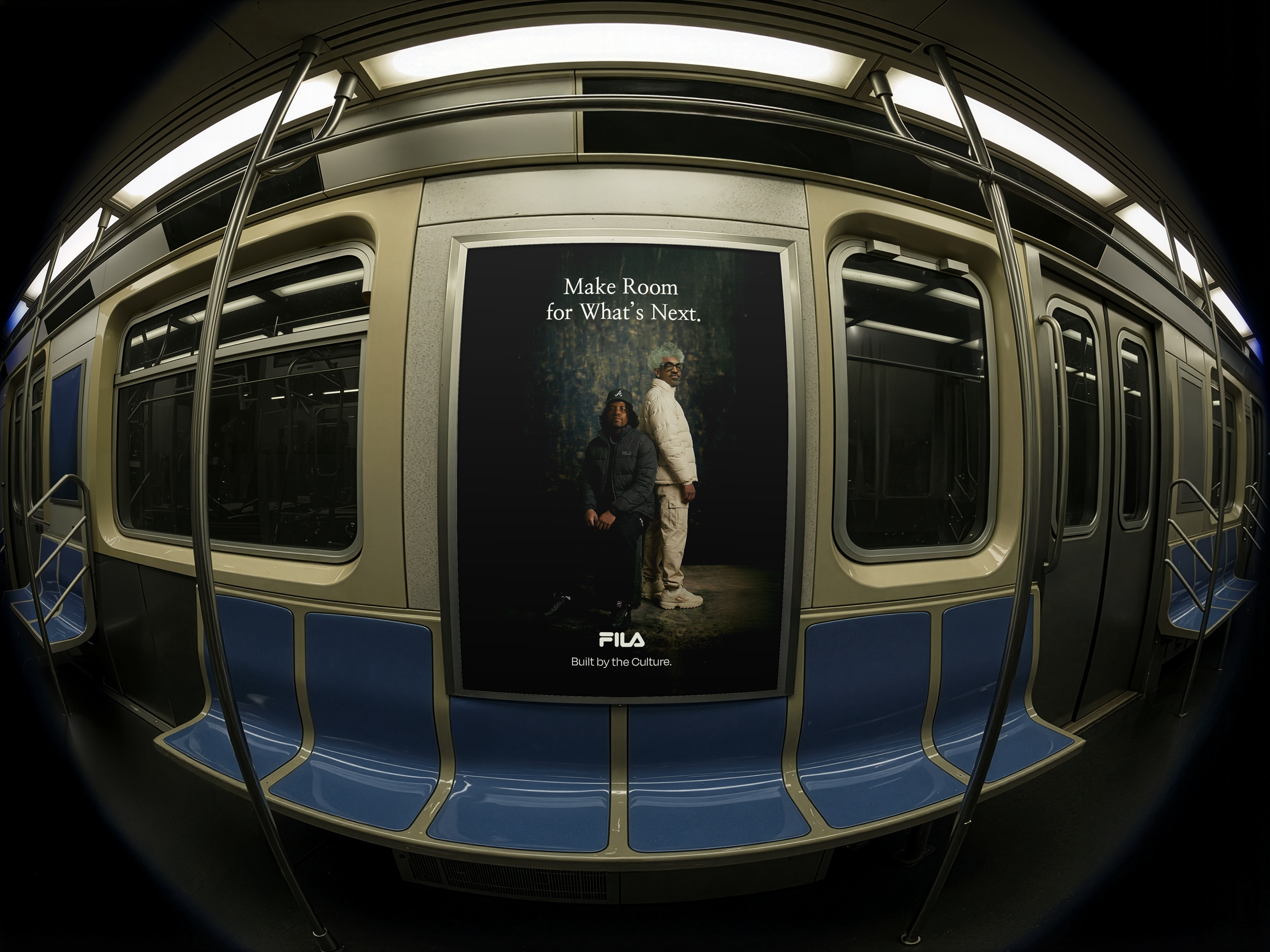 Inside a subway train, a digital advertisement displays a message saying 'Make Room for What's Next.' with two people standing in front of it. The train features metal handrails and windows, with overhead lighting illuminating the space.
