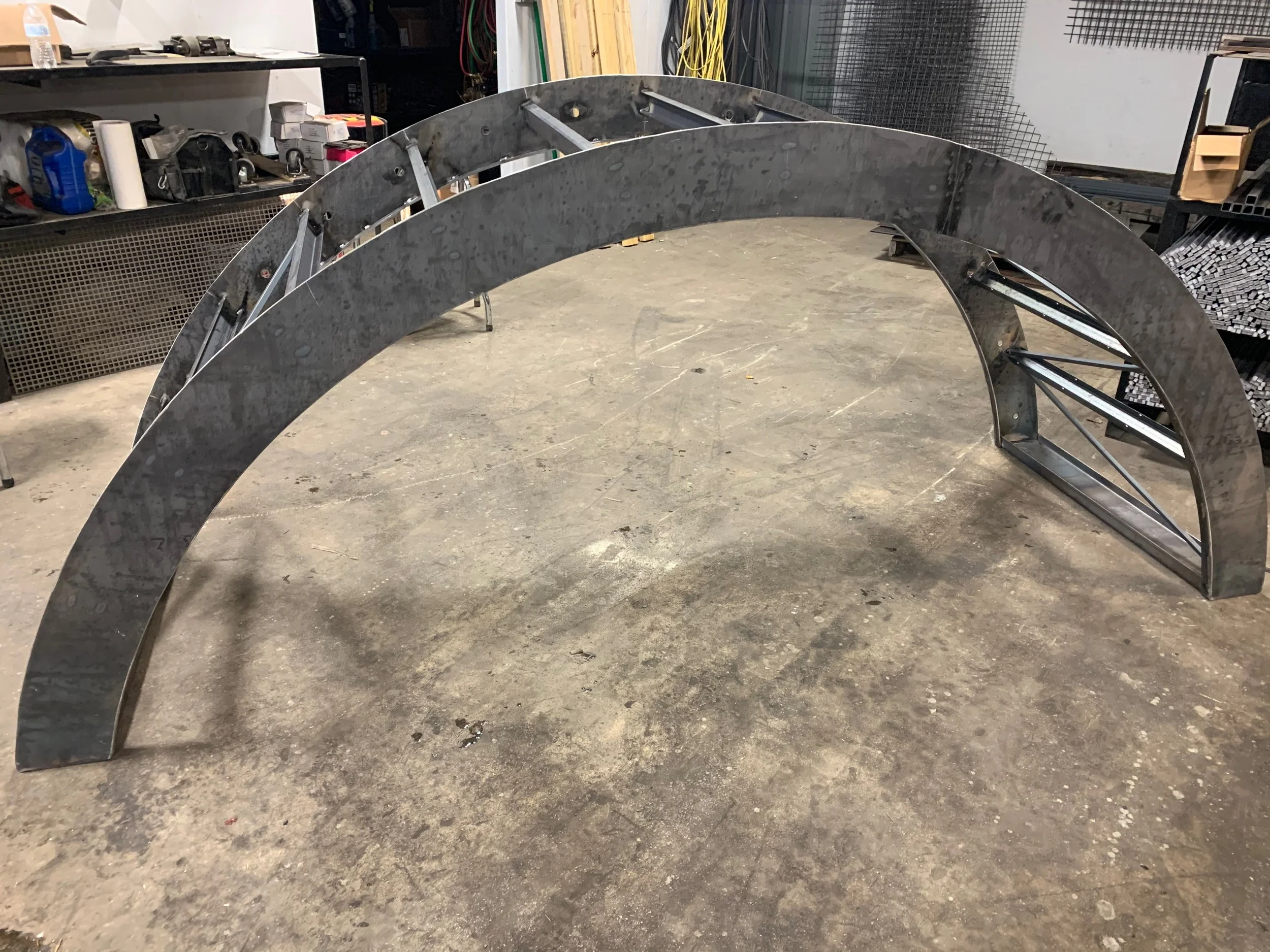Metal arches or frames in an industrial or workshop setting.