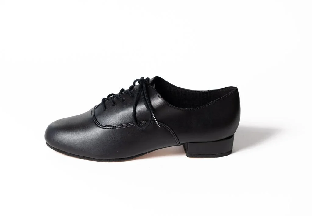 A black dance shoe with a low heel and laces