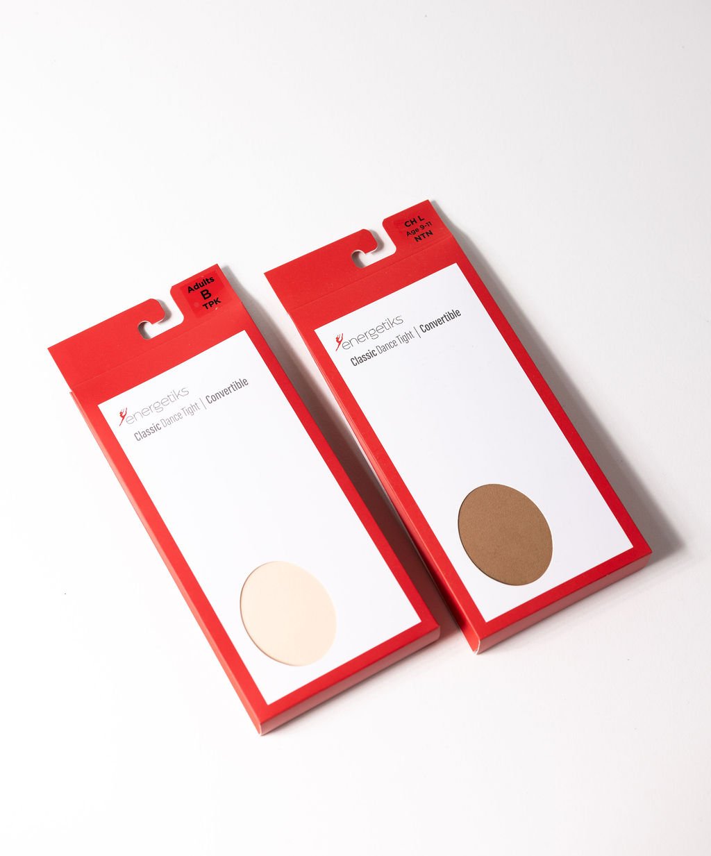 Two red packaging boxes for Energetiks classic dance tights, with pink and brown tights visible through circular windows, placed on a white surface.
