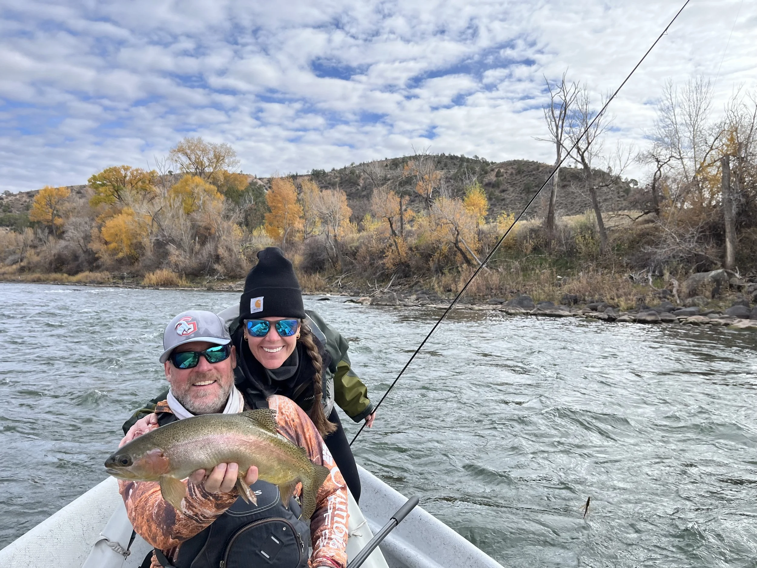 Jeremy Stott guiding clients on the Colorado River near Glenwood Springs, Colorado — holding a rainbow trout