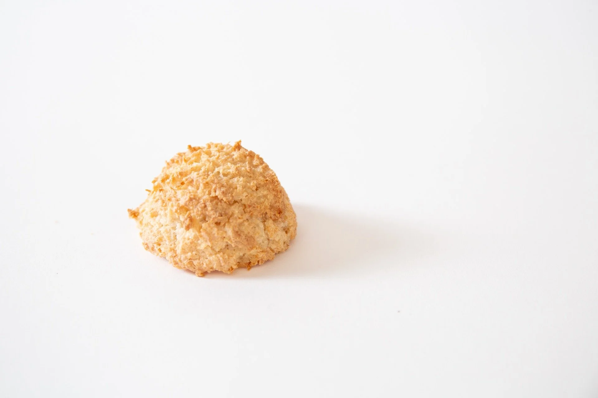 A single coconut macaron on a white background.
