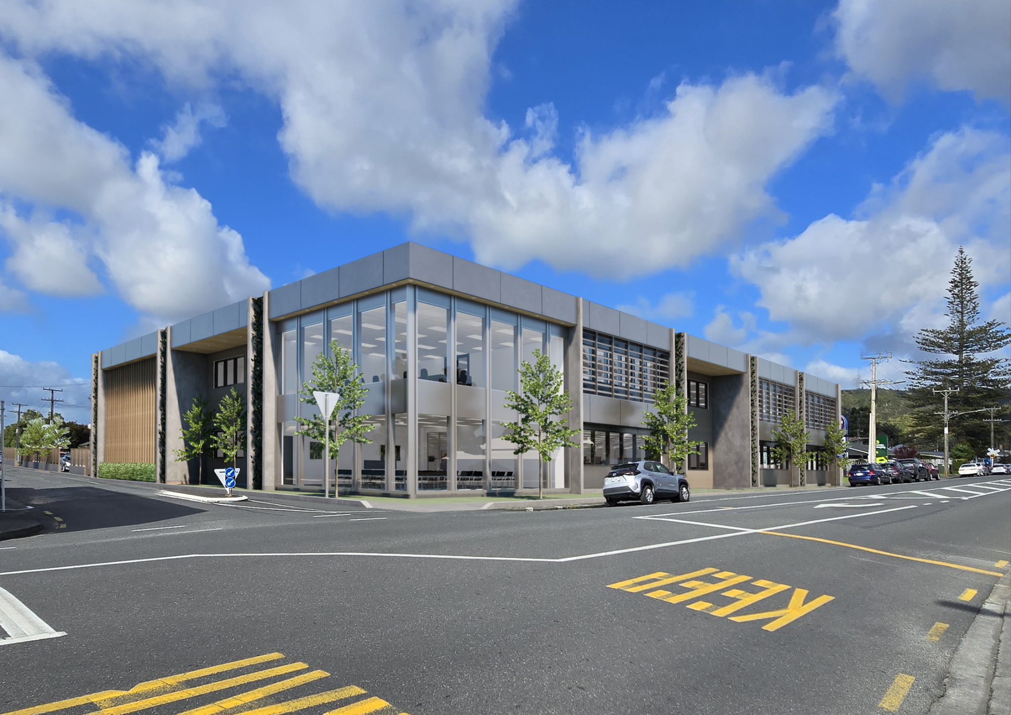 Modern two-story building with glass windows, trees in front, parked cars, and a blue sky with clouds.