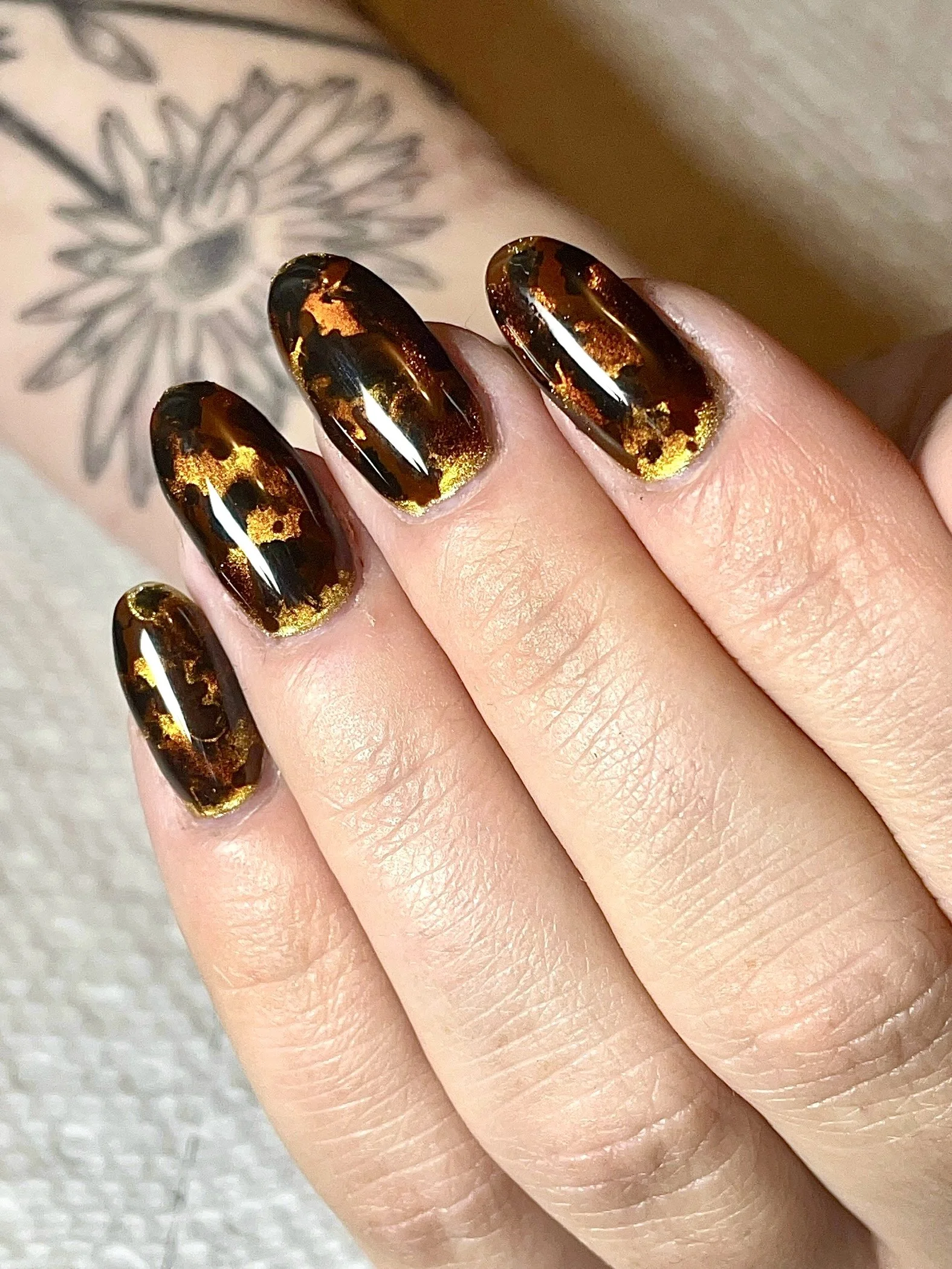 close-up of single hand with short round tortoise shell nails