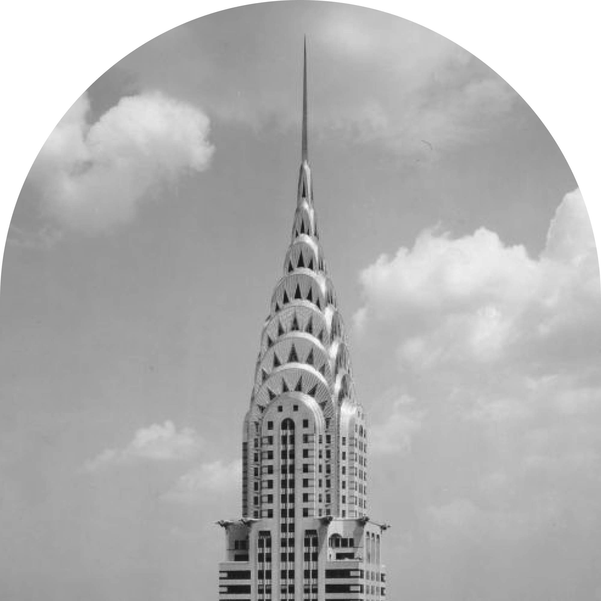 The Chrysler building, with a pointed spire at the top, viewed from below with a cloudy sky background.