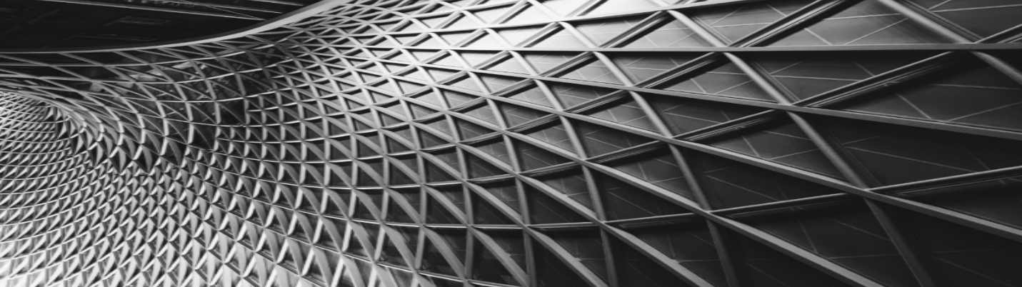 Close-up view of a modern architectural structure with a geometric, grid-like facade and curved design in black and white.
