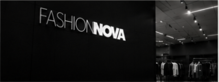 Fashion Nova store entrance with illuminated sign and clothing displays inside.